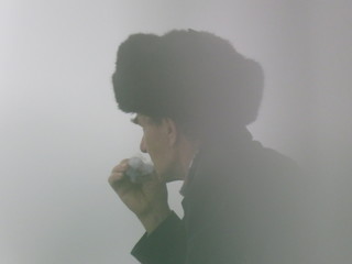 The silhouette of a Smoking man watching the fog