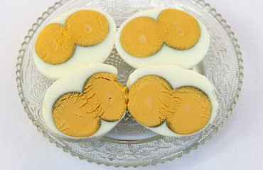 Two yolks in an egg, on saucer halfs cooked eggs
