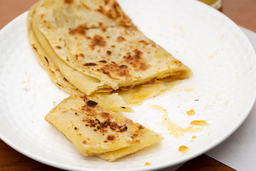 Moroccan Msemen with honey on plate. Square flatbread  served cafe, Marrakech, Morocco