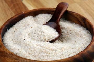 Portion of Psyllium Seeds on rustic dark background. Psyllium seed husks on wood