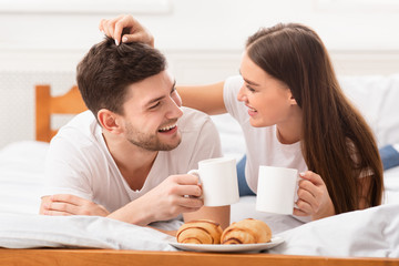 Joyful Couple In Love Having Breakfast In Bed In Bedroom