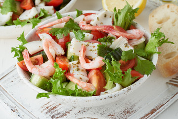 Seafood salad with squid, shrimp, cucumbers, tomatoes and lettuce. LCHF, FODMAP, paleo diet. Fresh spring vitamin mix.