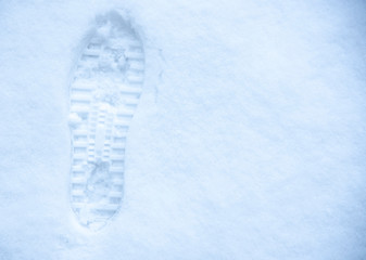 Embossed footprint on white snow. Winter time, copy space for text.