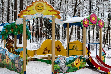 Winter. Playground the sun decorated with drawings of a bear, a bunny, a hedgehog and a kolobok.
