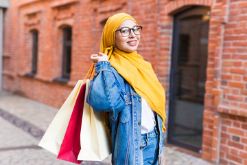 Sale and buying concept - Happy arab muslim girl with shopping bags after mall