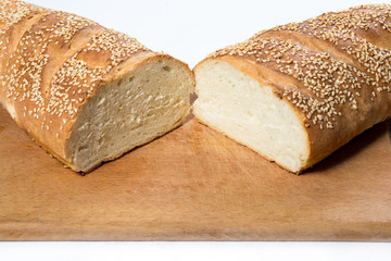 White bread with sesame seeds on kitchen board