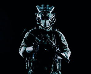 Army elite soldier with hidden behind mask and glasses face, in full tactical ammunition, equipped...