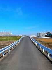 早春の田圃の中の坂道風景
