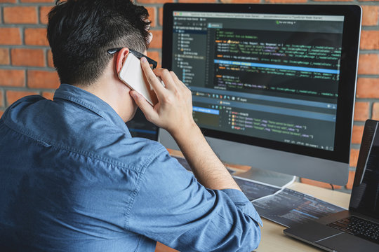 Young Professional programmer working at developing programming and website working in a software develop company office, writing codes and typing data code, Programming with HTML, PHP and javascript