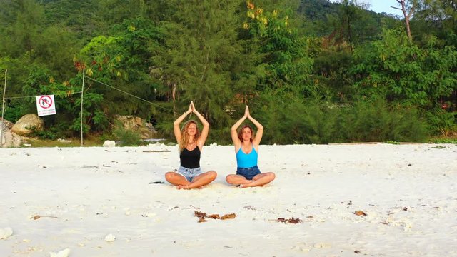 Yoga instructor teaching teenage girl yoga. Spirituality and mind relief on summer vacation.