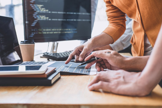 Programmers cooperating at Developing programming and website working in a software develop company office, writing codes and typing data code, Programming with HTML, PHP and javascript
