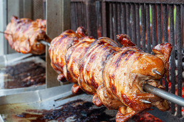 Rolling grilled chicken at a steet food shop in Thaland
