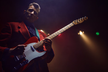 A guitarist perform on stage.