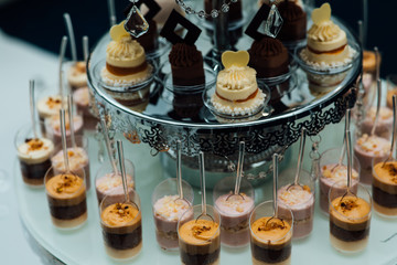 Holiday celebration, luxury wedding catering, table with modern desserts, cupcakes, sweets with fruits. delicious candy bar at expensive wedding reception.
