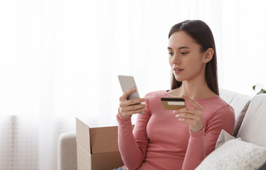 Young girl buying online with a credit card and smart phone