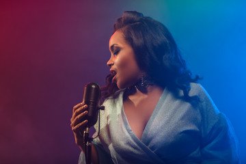 A jazz singer performs on stage. Afro.