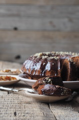 Festive homemade cakes. Round chocolate muffin, large biscuit or cake with chocolate icing on an ancient wooden background. Place for text, side view.