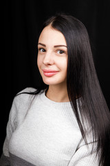 Portrait of serious beautiful female with black hair, has minimal makeup, looks calmly at camera,...