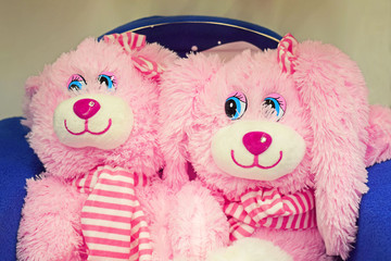Beautiful pink stuffed toys in a blue chair.