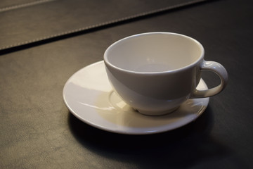 White tea Cup with saucer on a wooden background.