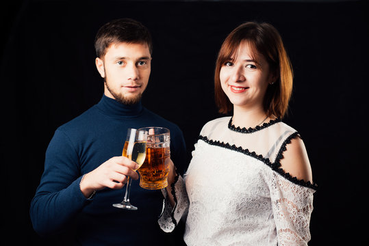 A man and a woman on a black background, a woman drinking beer and a man drinking champagne is a stereotypical activity