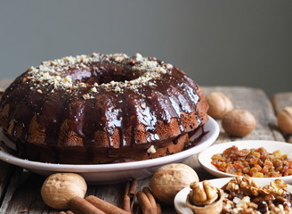 Festive homemade cakes. Round chocolate muffin, large biscuit or cake with chocolate icing on an ancient wooden background. Place for text, side view.
