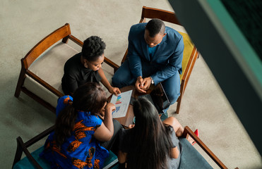 African businesspeople discussing graphs during a meeting in an office