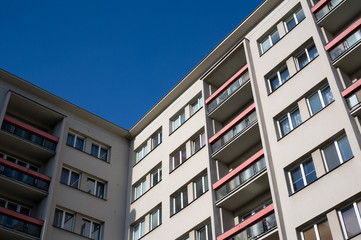 Obraz premium Blocks of flats and house with apartments - residential building windows and balconies. Clear blue sky.