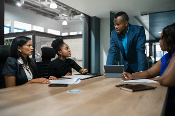 African businessman discussing work with his staff during a meeting