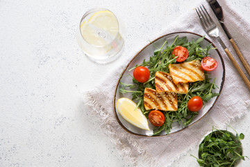 fresh salad with grilled halumi cheese, cherry tomatoes and arugula. copy space.