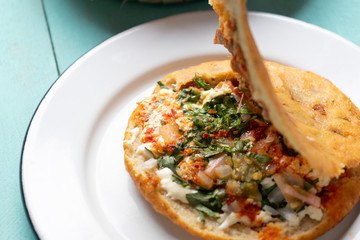 Mexican gorditas with pressed chicharron on turquoise background