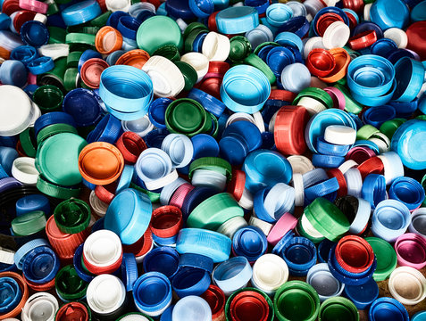High resolution background top view at various color and sizes plastic medical pill bottles caps spread on floor.