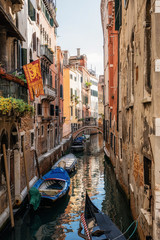Fototapeta na wymiar Boats in narrow canal between ancient houses, Venice, Italy