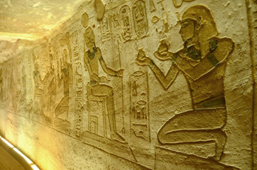 Interior of Abu Simbel with intrigue mural and egyptian hieroglyphs.