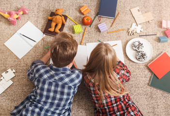 Unrecognizable Brother And Sister Drawing Together Lying On Floor