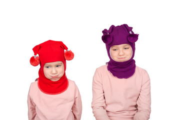 Two girls in funny knitted winter caps look at the camera and make funny faces