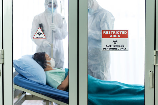 Coronavirus Covid 19 Quarantine Room With Coronavirus Covid 19 And Restricted Area Sign With Blurred Female Infected Coronavirus Patient And Disease Control Experts Wearing Virus Protective Suit