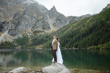 Loving couple on the background of the Sea-eye lake in Poland