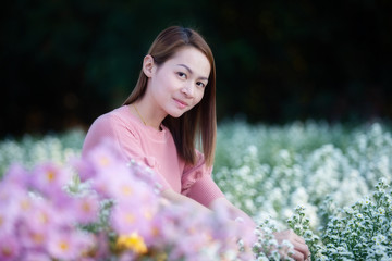 Beautiful Asian portrait woman enjoying with the flower