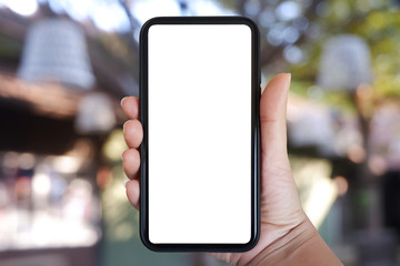 Close-up hand holding phone vertical, Using smart phone with blurred background of house, cafe interior - copy space