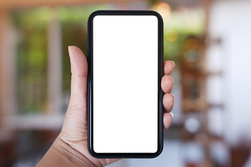 Close-up hand holding phone vertical, Using smart phone with blurred background of house, cafe interior - copy space