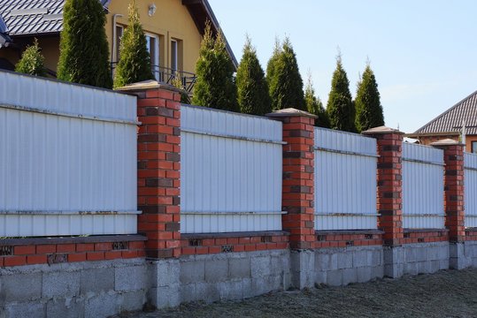 gray metal fence wall and red bricks on the street