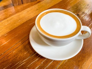 The cup of hot latte coffee or coffee espresso on wood table