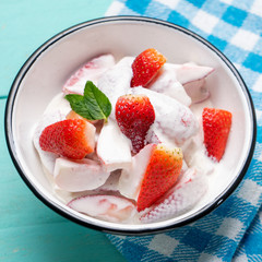 Strawberries and cream dessert on turquoise background