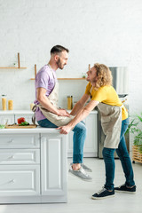 profile of happy homosexual men looking at each other at home