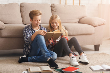 Siblings Reading Book Learning Together Sitting On Floor Indoor