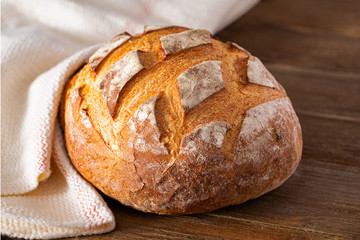 Loaf of freshly baked artisan bread on a wooden surface