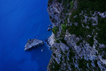 Aerial view of sea and rocky coast on sunny day.