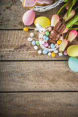 Easter hot chocolate with chocolate bunny rabbits. easter eggs and marshmallow, wooden background with spring flowers copy space