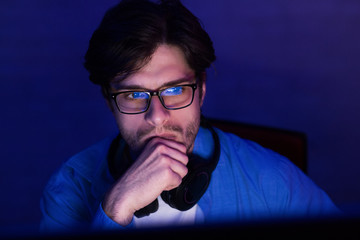 Thoughtful Developer Looking At Computer Screen Working From Home, Low-Light